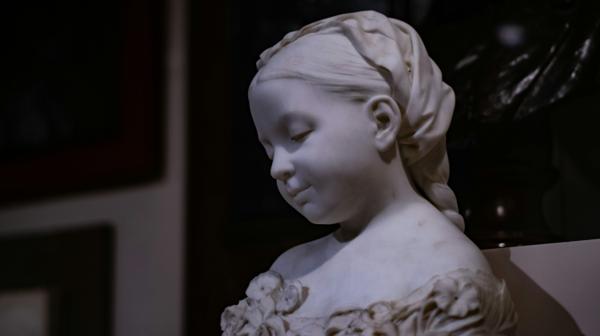 Figurative marble sculpture bust with dramatic side lighting revealing texture and form